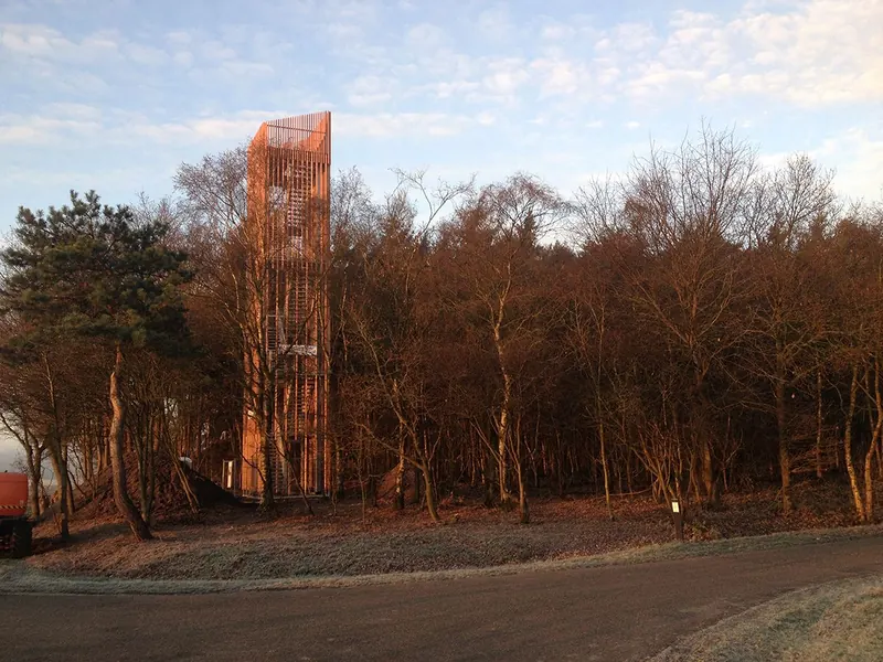 Uitkijktoren boven de bomen in avondlicht